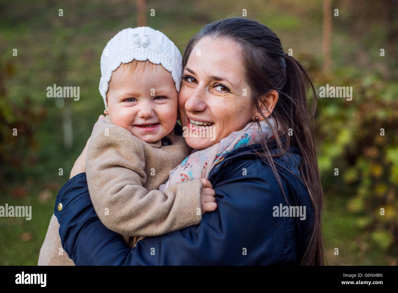 Mother holding her baby fille, à l'extérieur en hiver Banque D'Images