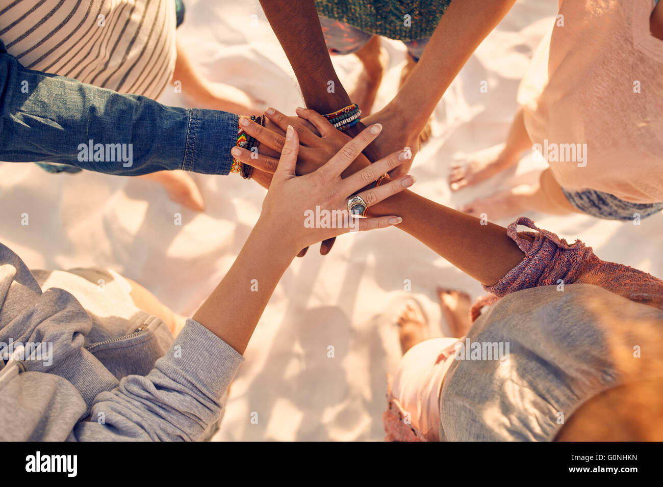 Image Gros plan des mains de jeunes gens sur pile. Groupe d'amis race mixte sur la plage avec leurs mains empilés. Banque D'Images