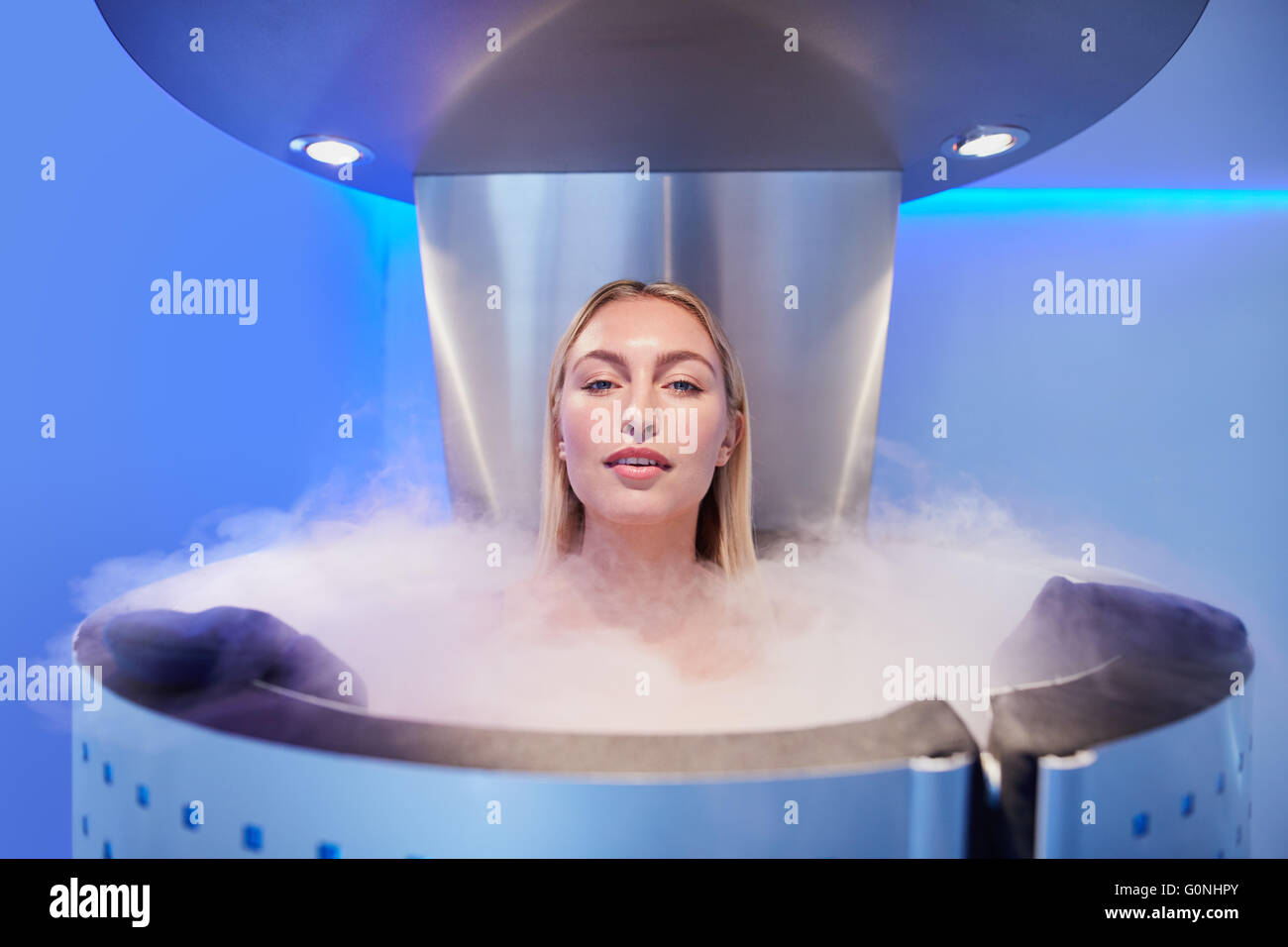 Portrait d'une belle jeune femme en cryosauna cabine pour la cryothérapie du corps entier. Les femmes de race blanche dans la pièce de refroidissement avec nit Banque D'Images