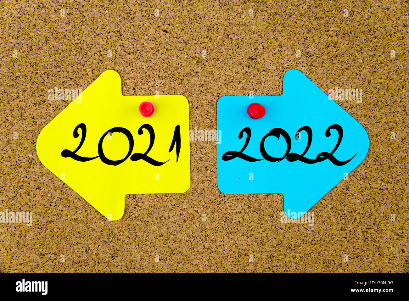 Message conceptuel sur papier bleu et jaune notes comme flèches opposées épinglé sur le panneau de liège avec punaises Banque D'Images