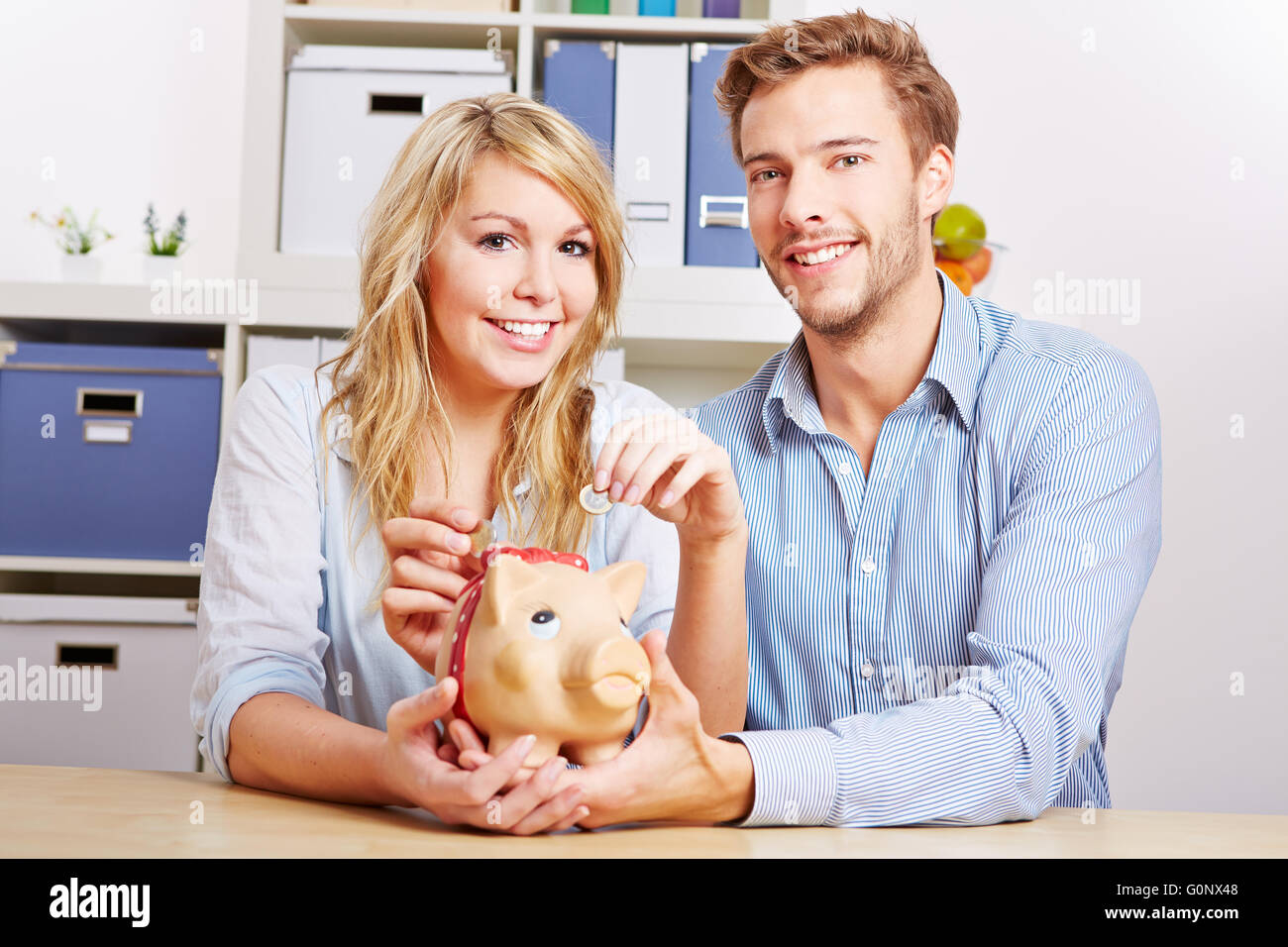 Jeune couple heureux avec de l'argent Euro d'économie a piggy bank Banque D'Images