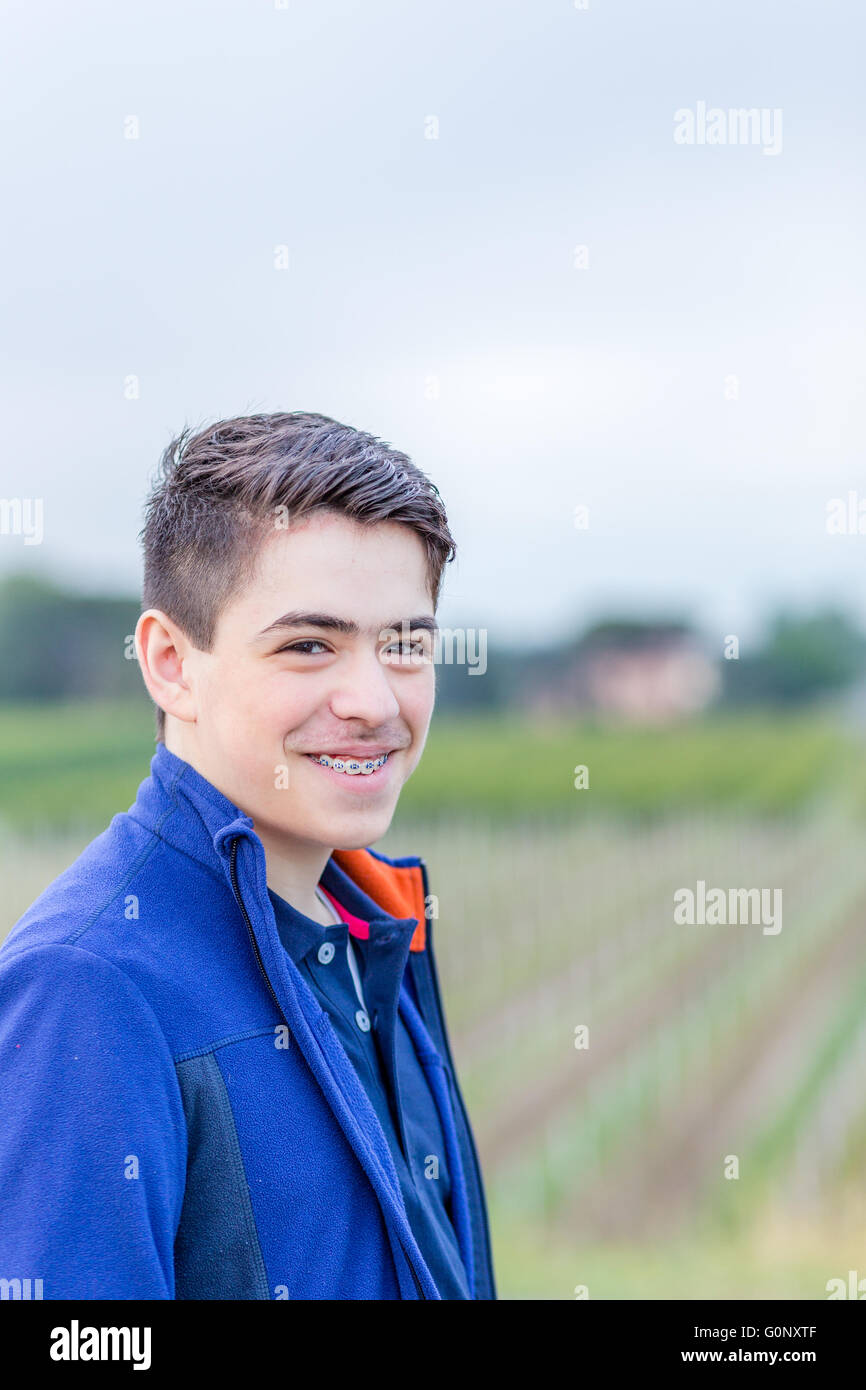Close up of young boy in countryside riant et montrant les accolades Banque D'Images