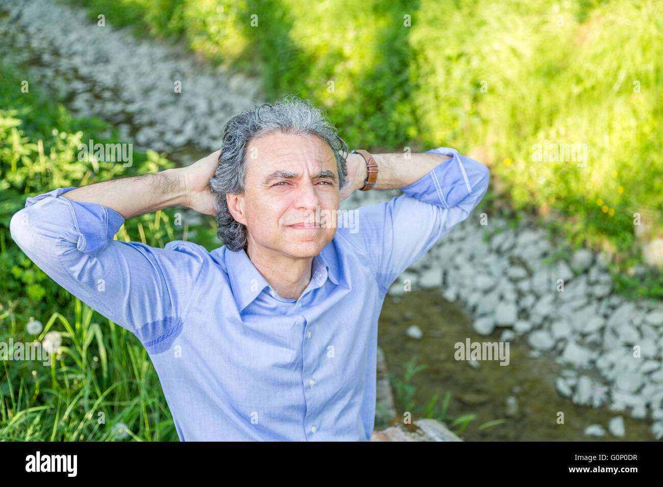 La transpiration des aisselles en chemise tachée avec un homme d'âge moyen  avec ses mains derrière sa tête Photo Stock - Alamy