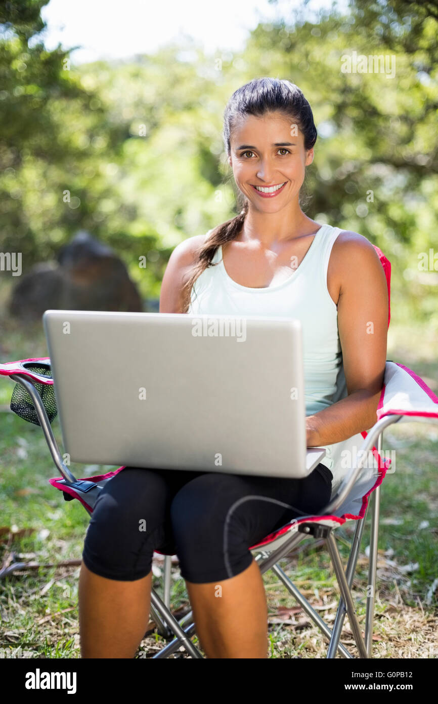 Woman smiling and using a laptop Banque D'Images