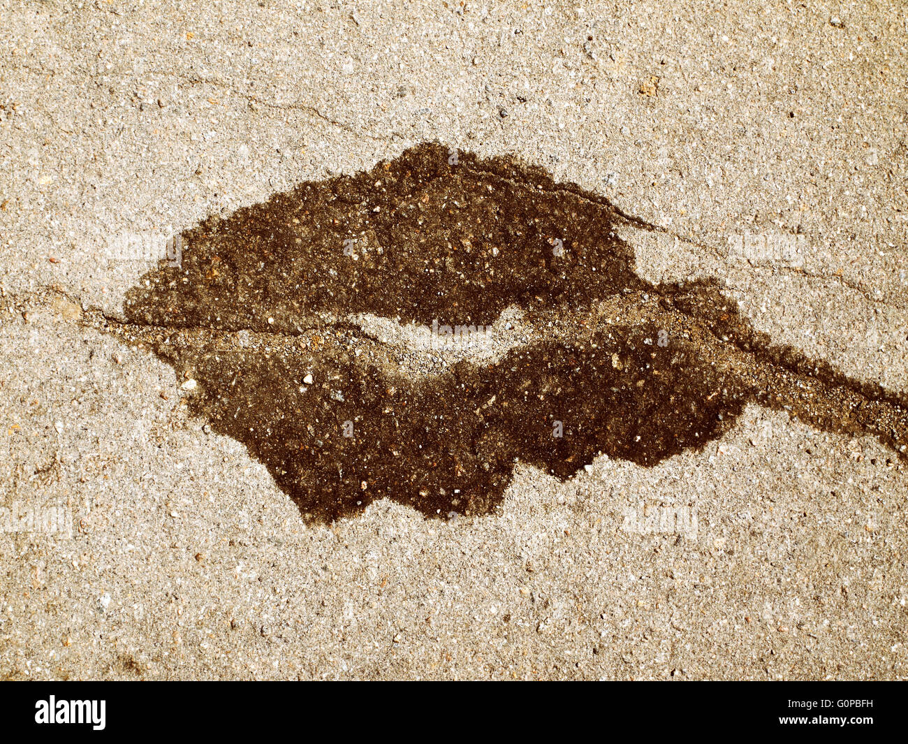 Tache sombre sur l'asphalte en forme de grain de café Banque D'Images