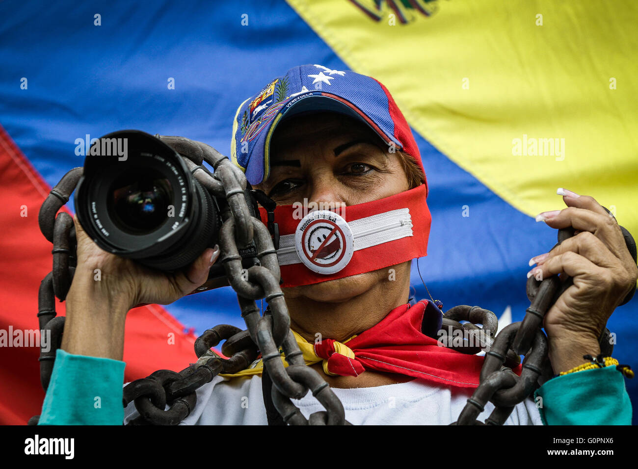 Caracas, Venezuela. 3 mai, 2016. Une femme avec la bouche couverte est titulaire d'un appareil photo et d'une chaîne au cours d'une marche pour la liberté de parole sur la Journée mondiale de la liberté de la presse à Caracas, capitale du Venezuela, le 3 mai 2016. © Boris Vergara/Xinhua/Alamy Live News Banque D'Images
