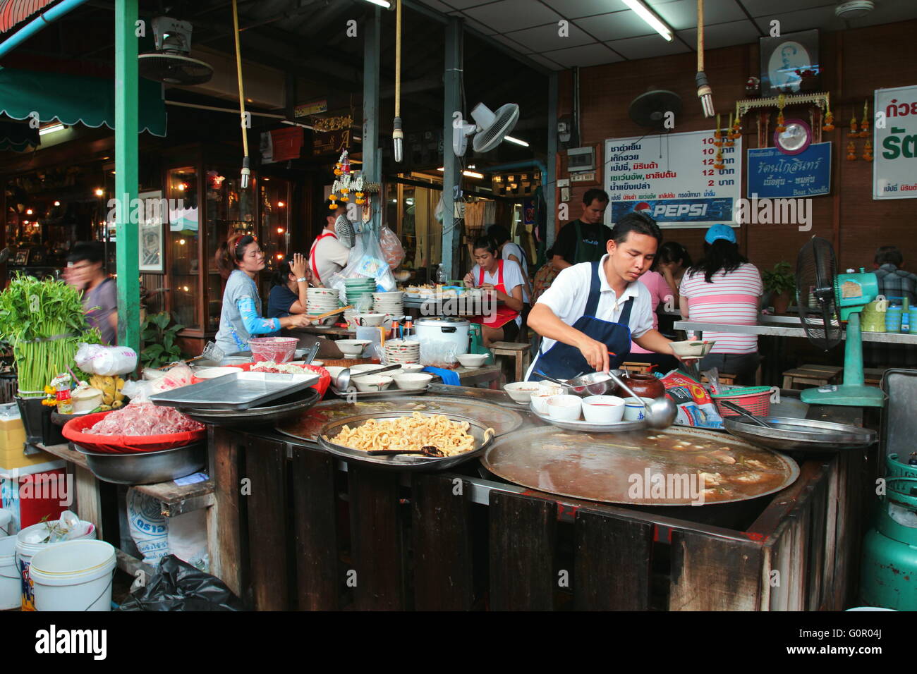 Food dans Chatuchak Weekend Market, Bangkok. Un homme occupé à préparer la nourriture pour les clients. Banque D'Images