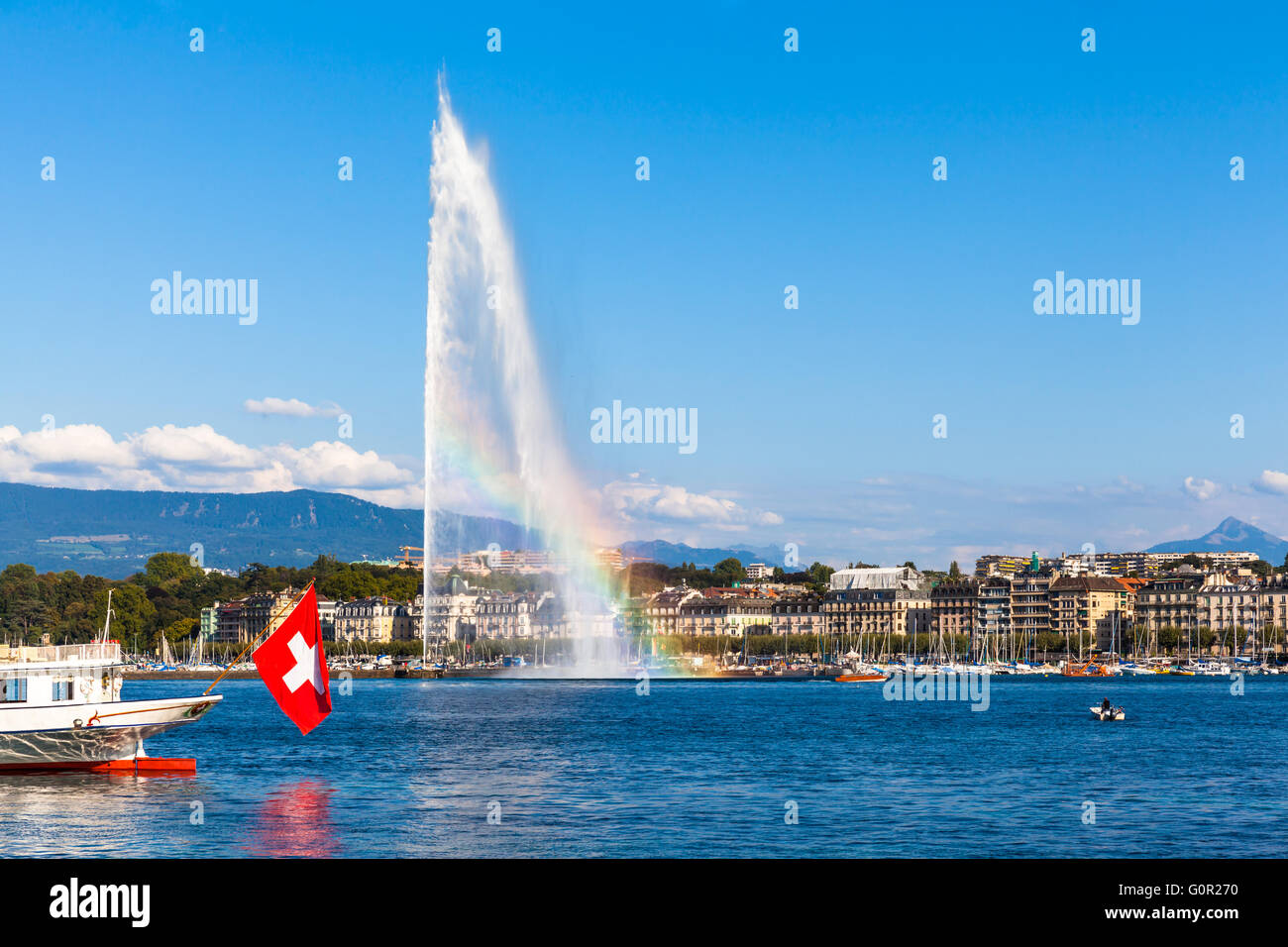 Belle vue sur le jet d'eau fontaine avec arc-en-ciel dans le lac de Genève et la ville de Genève, Suisse, au coucher du soleil Banque D'Images