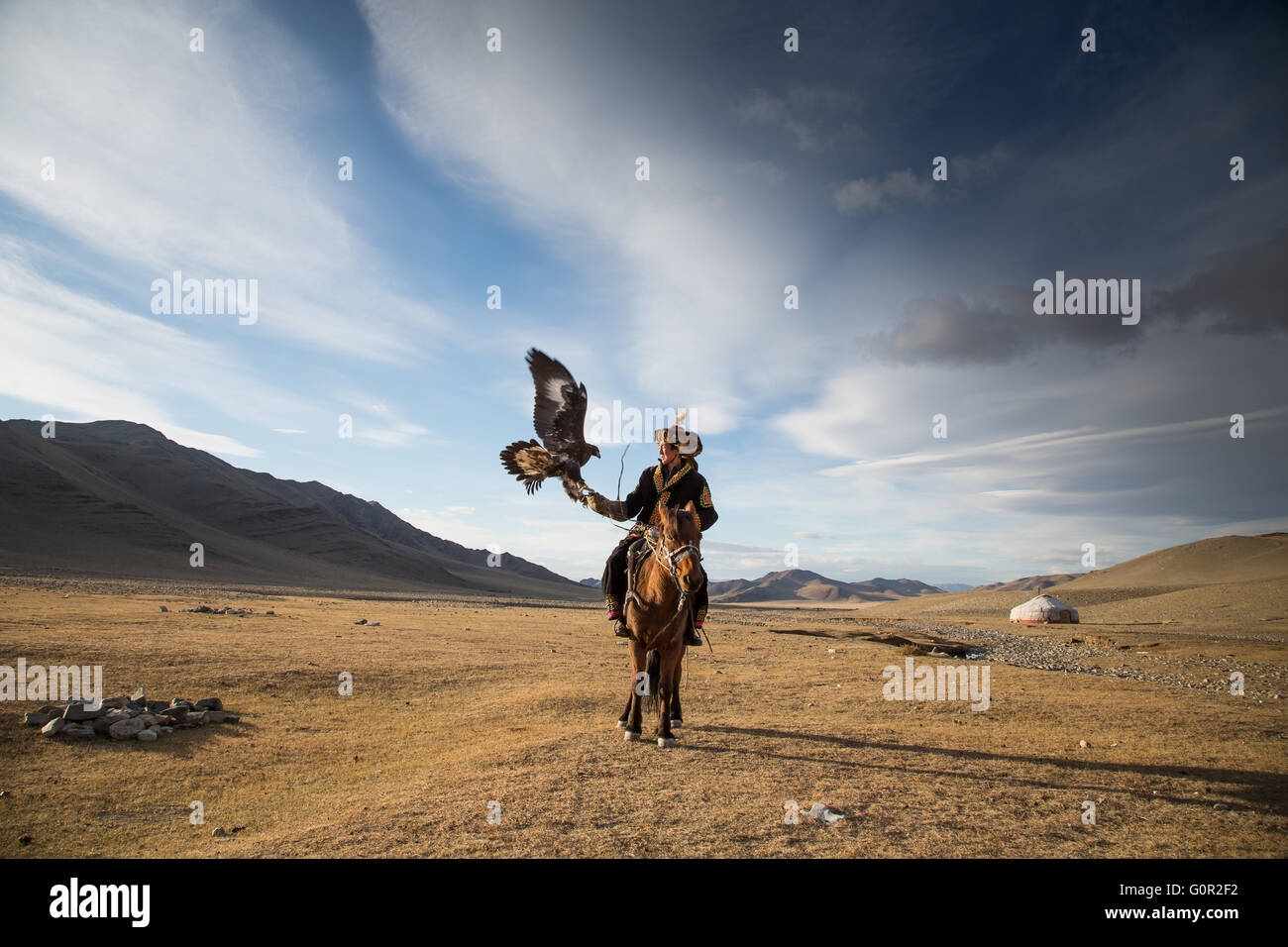 L'homme en costume traditionnel, sur un cheval, tenant un aigle doré sur son bras Banque D'Images