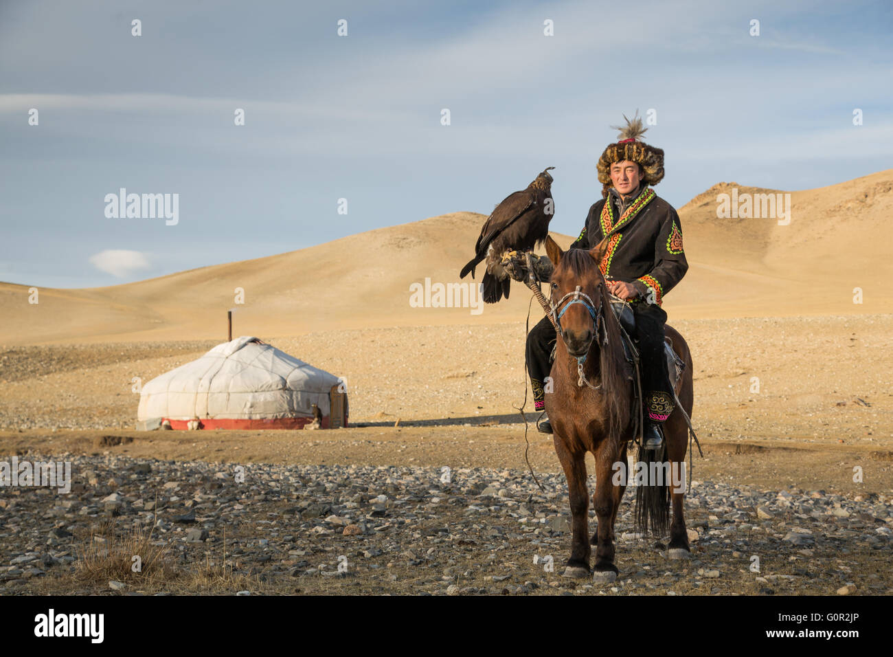 L'homme en costume traditionnel, sur un cheval, tenant un aigle doré sur son bras Banque D'Images