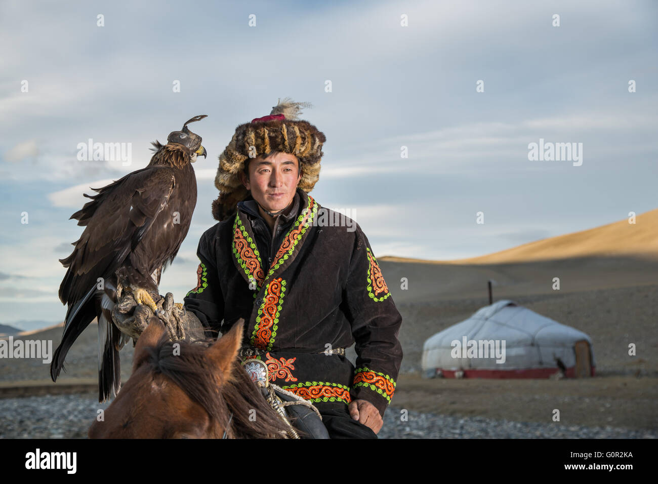 L'homme en costume traditionnel, sur un cheval, tenant un aigle doré sur son bras Banque D'Images