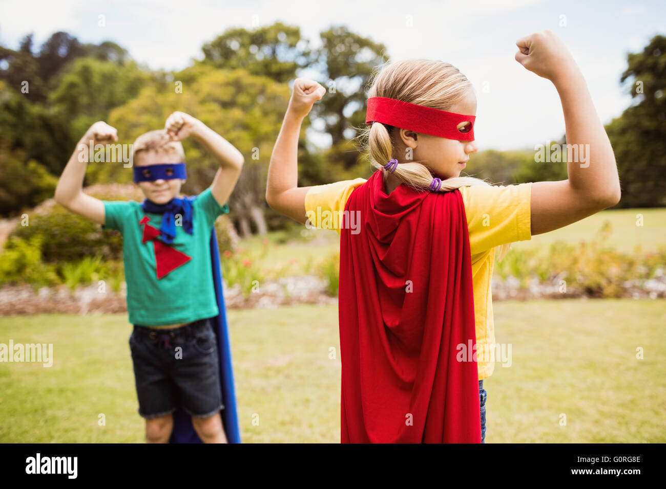 Enfants wearing superhero costume posant pour l'appareil photo Banque D'Images