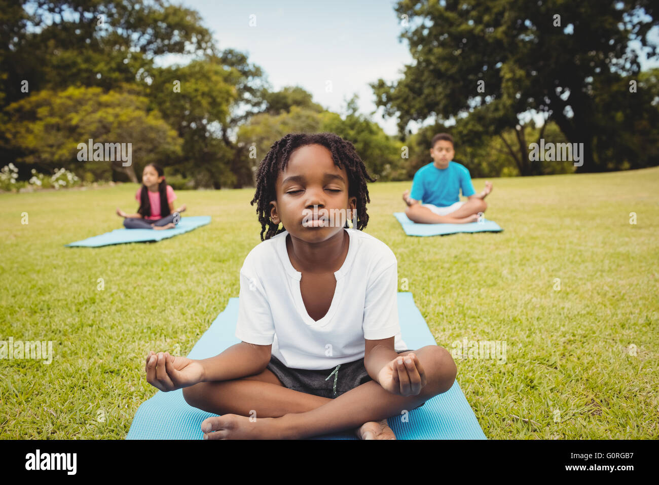 Portrait des enfants faisant du yoga avec des amis Banque D'Images