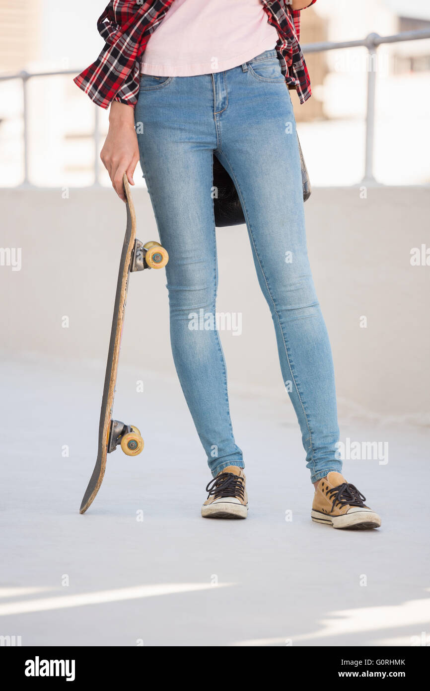 Hipster holding a skateboard Banque D'Images