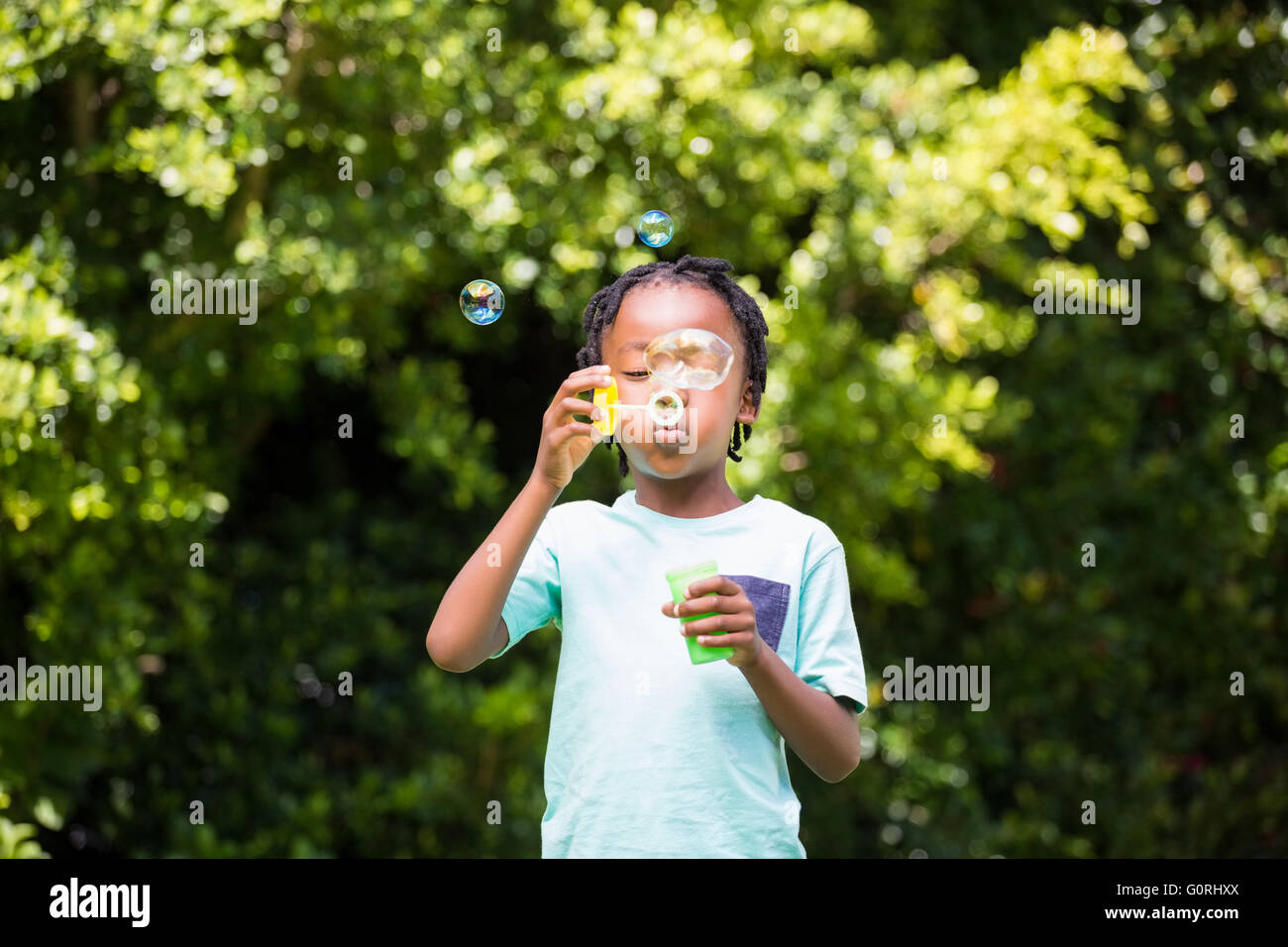 Un petit garçon blowing bubbles Banque D'Images