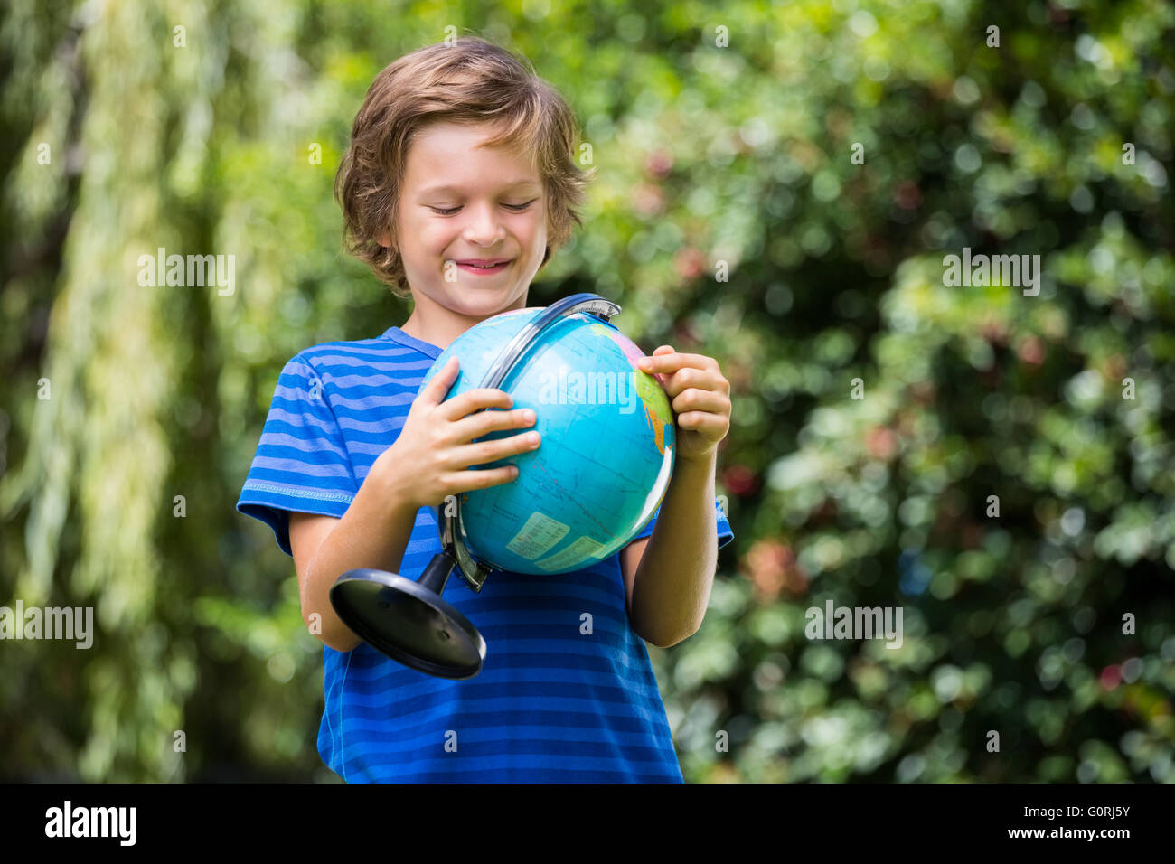 Un petit garçon est holding a globe Banque D'Images