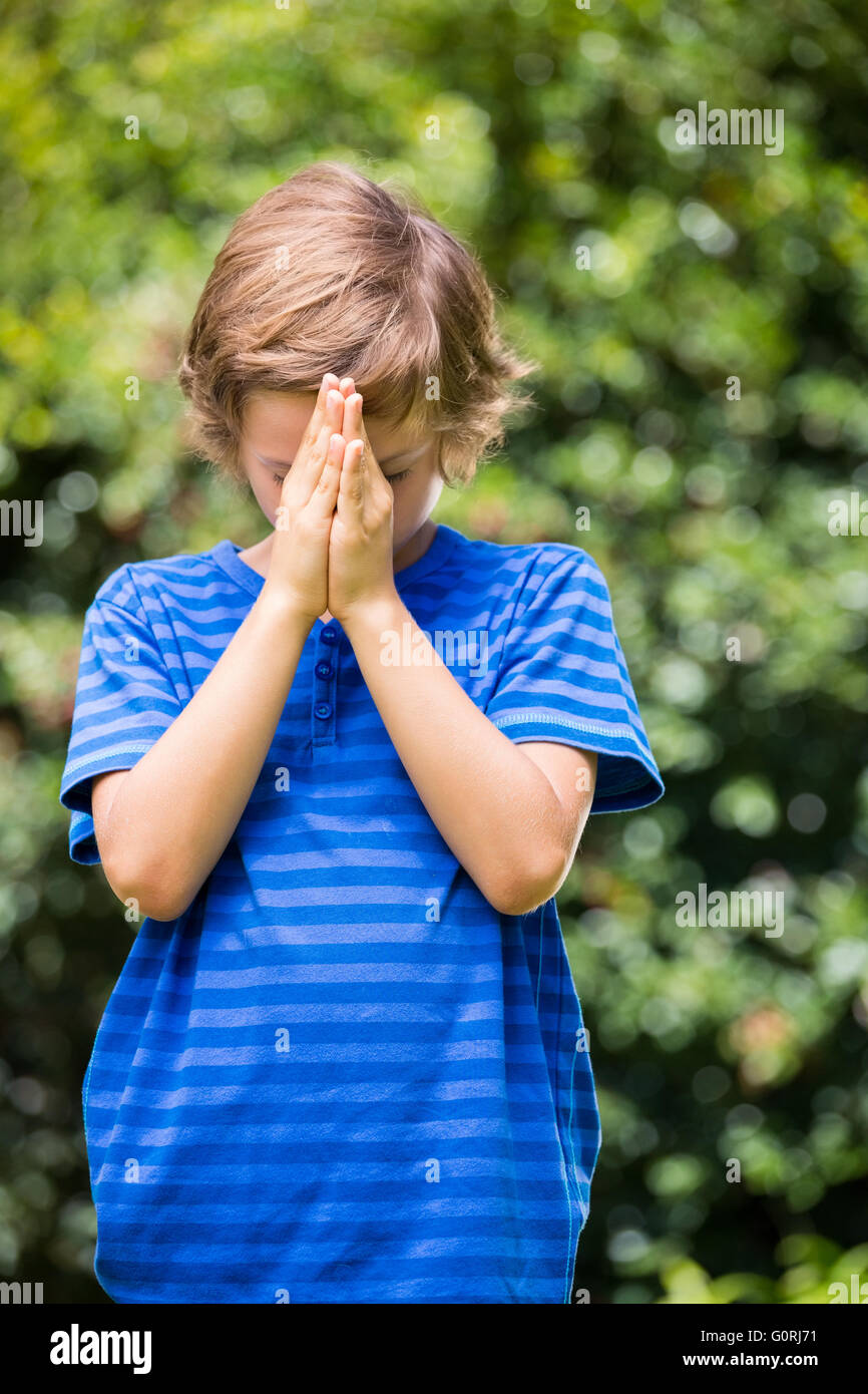 Portrait de garçon debout et priant Banque D'Images