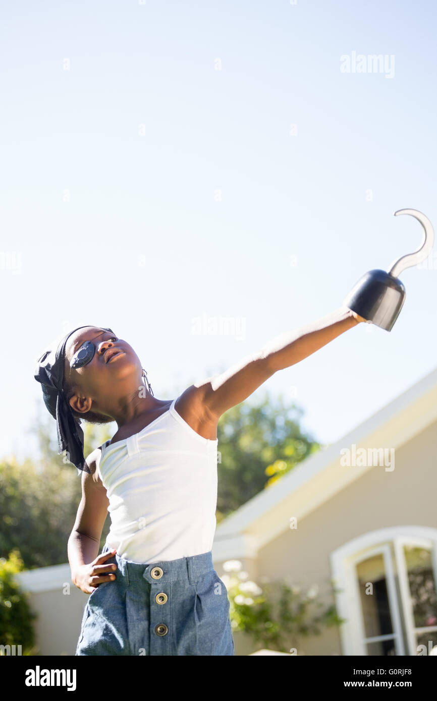 Cute girl de race mixte vêtements pirate et en pointant avec un hook Banque D'Images