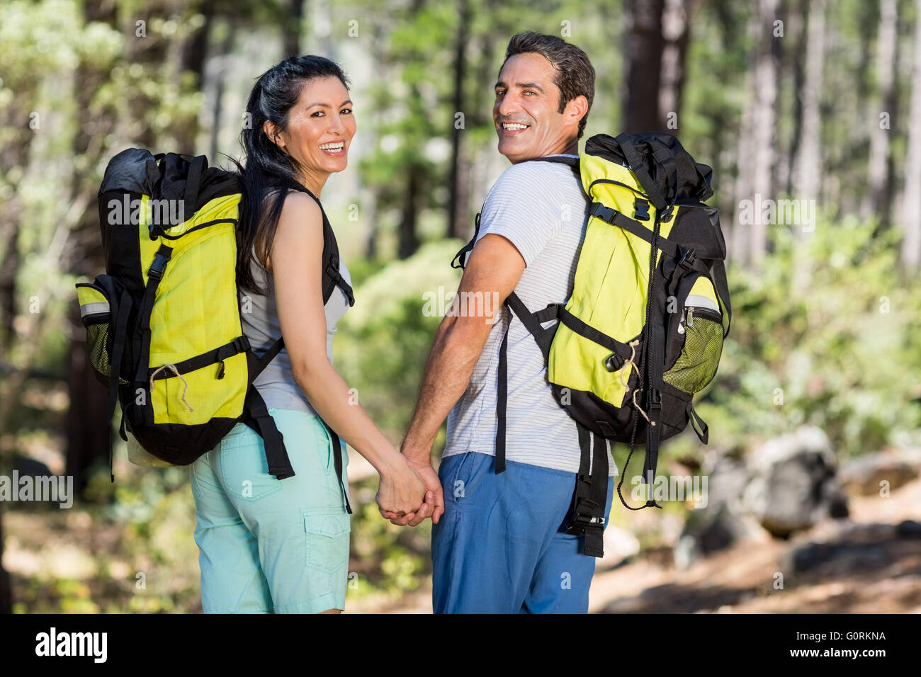 Couple de l'arrière en souriant et en tournant autour de l'appareil photo Banque D'Images