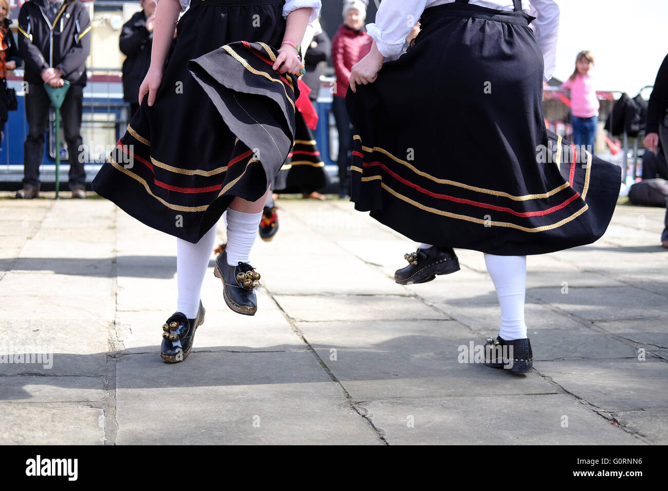 Pieds d'une troupe de danse montrant les sabots et les robes qui coule sur une chaussée en pierre du Yorkshire. Banque D'Images