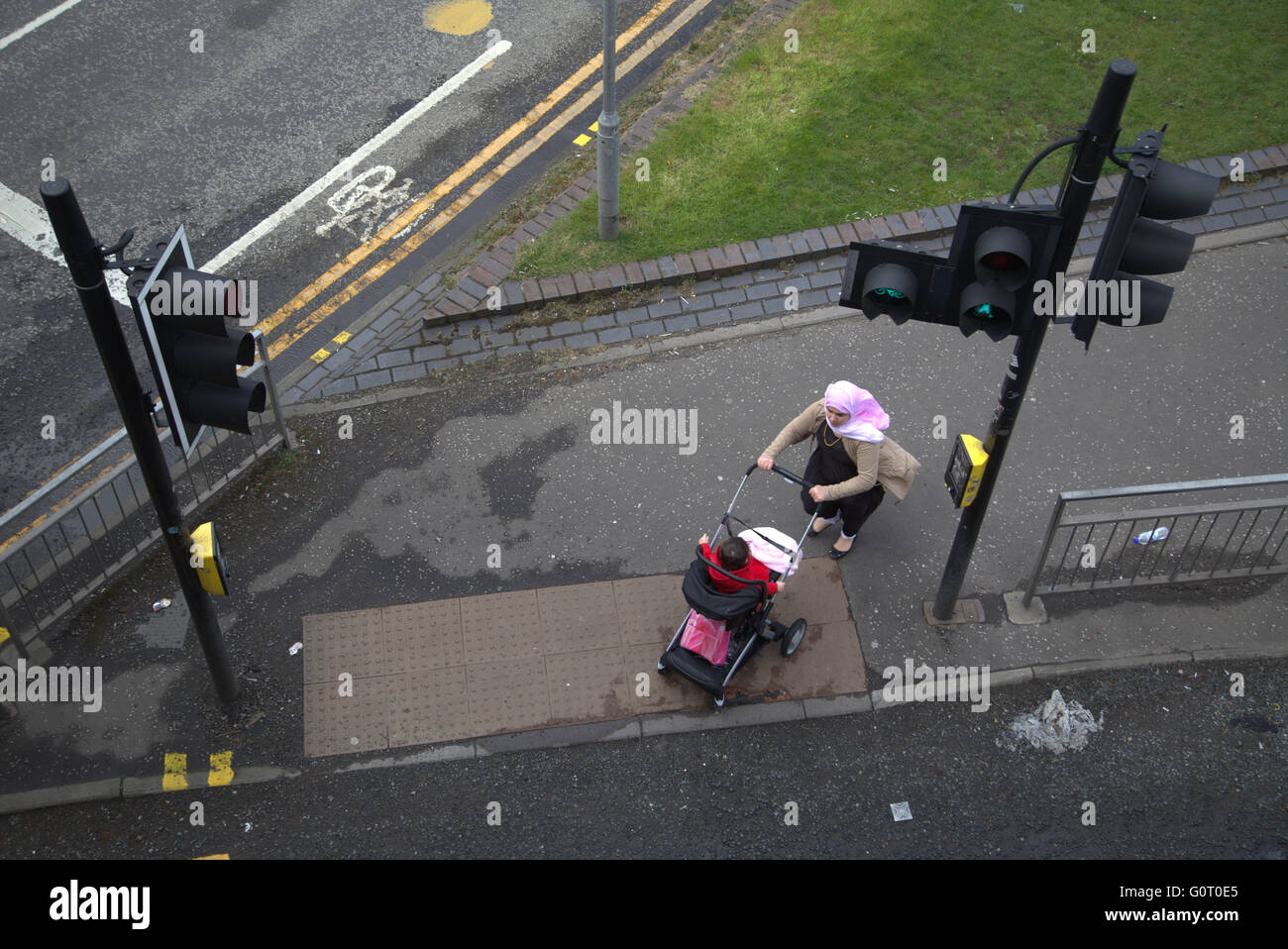 Famille d'immigrants sur la chaussée près de feux de circulation, Glasgow, Ecosse Banque D'Images