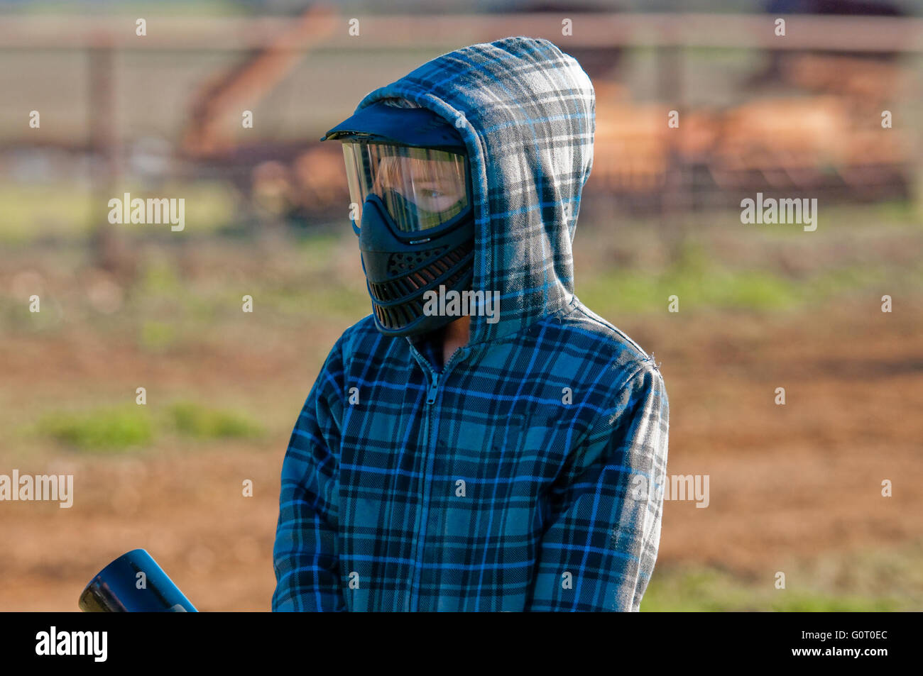 Garçon en masque et veste en jouant paint ball à l'extérieur. Banque D'Images