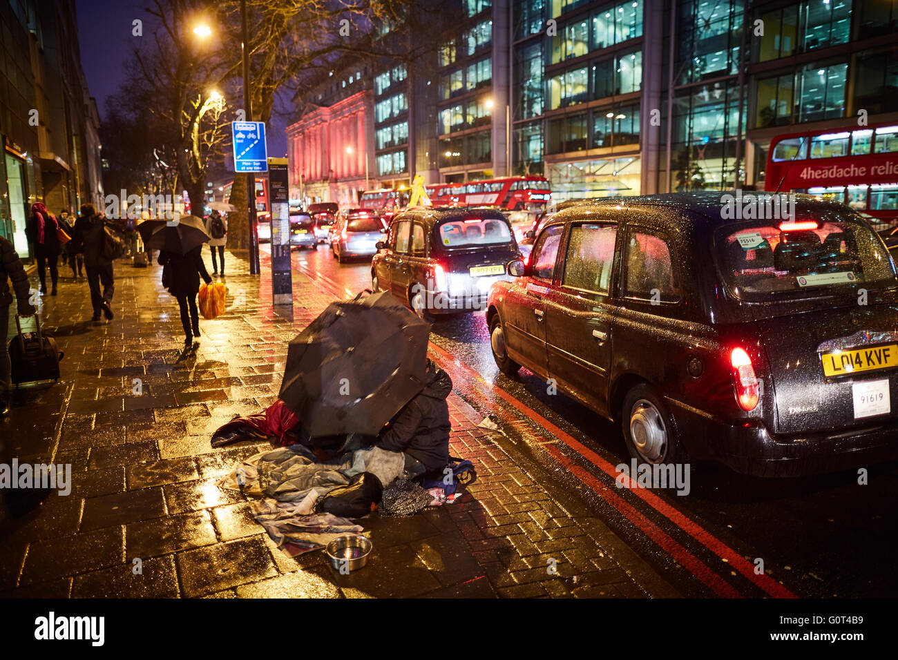 Plus de sans-abri sous la chaussée la mendicité tente dans la pluie pluie humide froid météo A501 de nombreux taxis passant une nuit sombre soir501 Banque D'Images