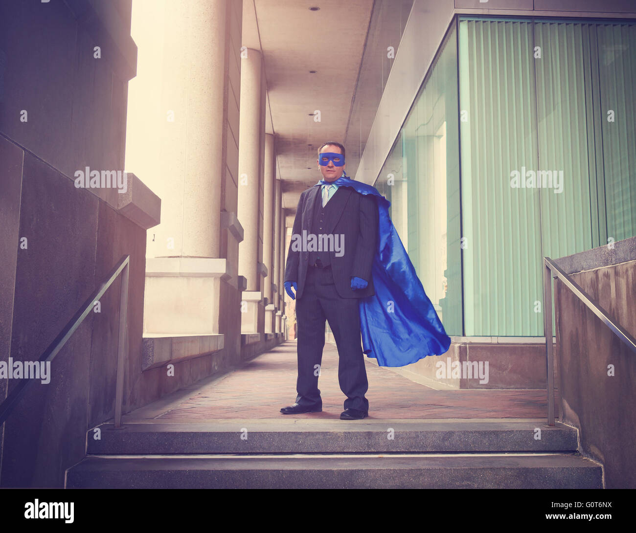 Un homme porte un costume bleu de super héros avec un costume dans une ville pour une réussite professionnelle ou de l'innovation concept. Banque D'Images