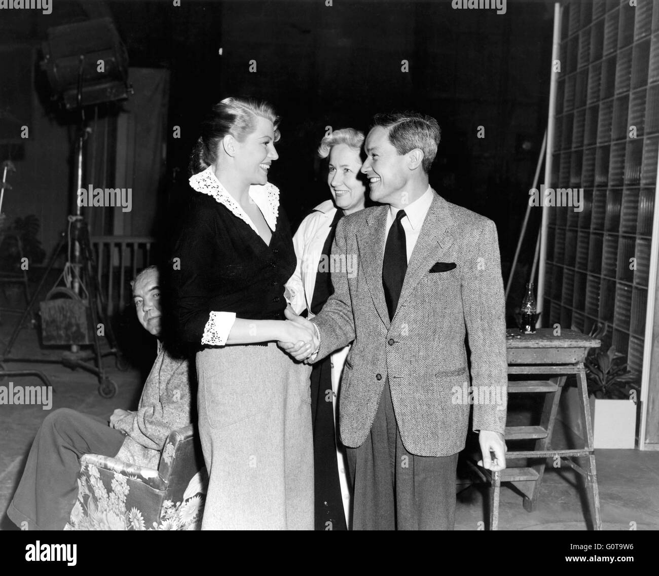 Rita Hayworth accueille Jean Louis, qui a conçu son armoire / Affair à Trinité / 1952 réalisé par Vincent Sherman (Columbia Pictures) Banque D'Images