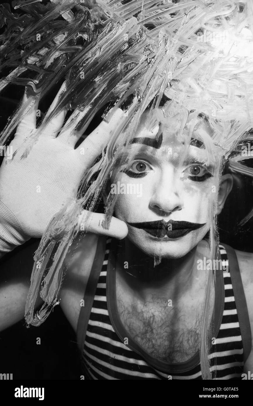 Portrait noir et blanc du Mime derrière la vitre Banque D'Images