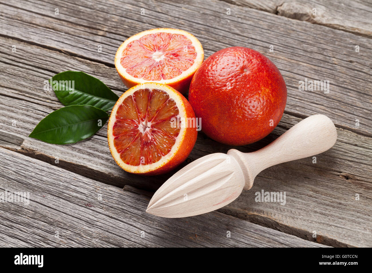 Oranges et rouges frais mûrs centrifugeuse sur table en bois Banque D'Images Oranges et rouges frais mûrs centrifugeuse sur table en bois Banque D'Images