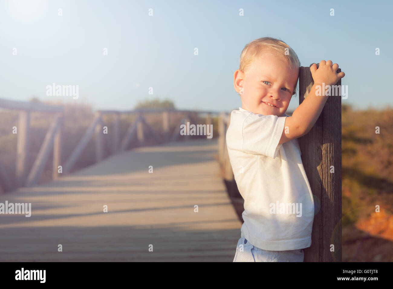 Portrait of a smiling boy standing on boardwalk Banque D'Images