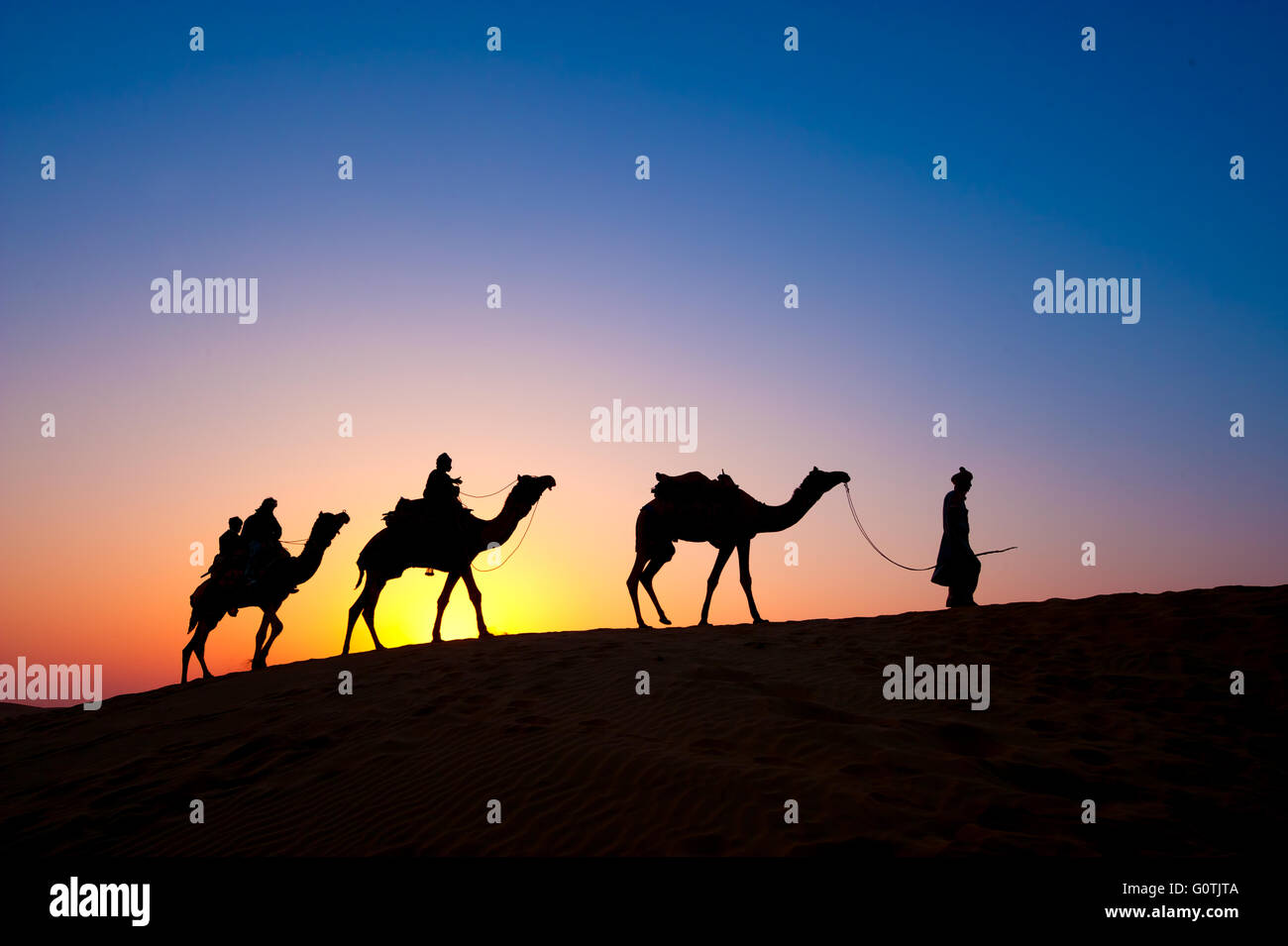 Silhouette de trois personnes sur safari de chameau, Thar Desert National Park, Jaisalmer, Rajasthan, India Banque D'Images