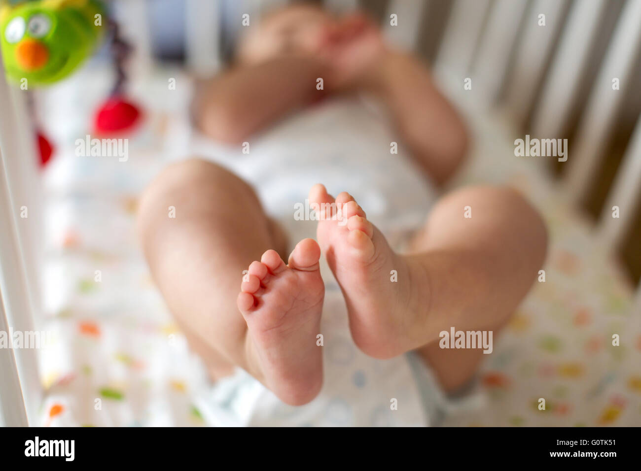 Baby Boy lying on lit dans la chambre à coucher Banque D'Images