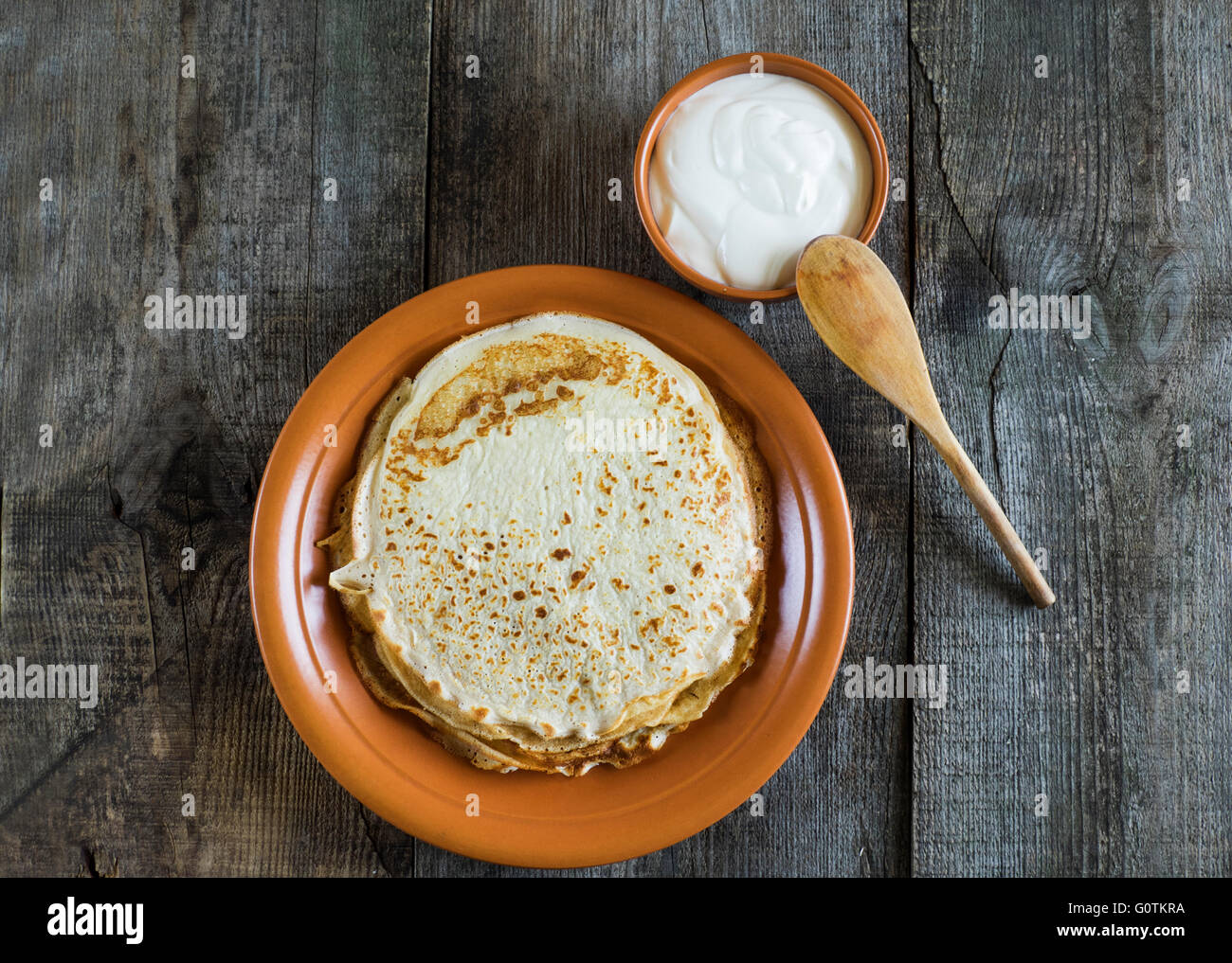 Pile de crêpes crêpe sur la plaque avec pot de crème Banque D'Images