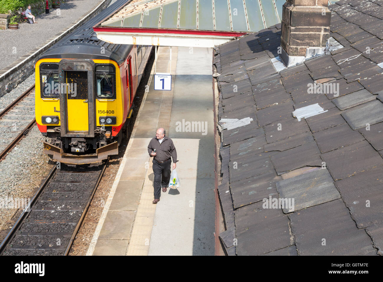 Personne qui quitte un train de marcher le long d'une plate-forme à Matlock, Gare, Derbyshire, Angleterre, RU Banque D'Images
