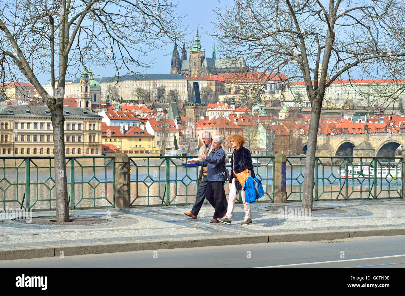 Prague, République tchèque. Smetanovo Nabrezi / Smetana remblai. Vue sur le château sur la rivière, les gens marcher, parler passé Banque D'Images