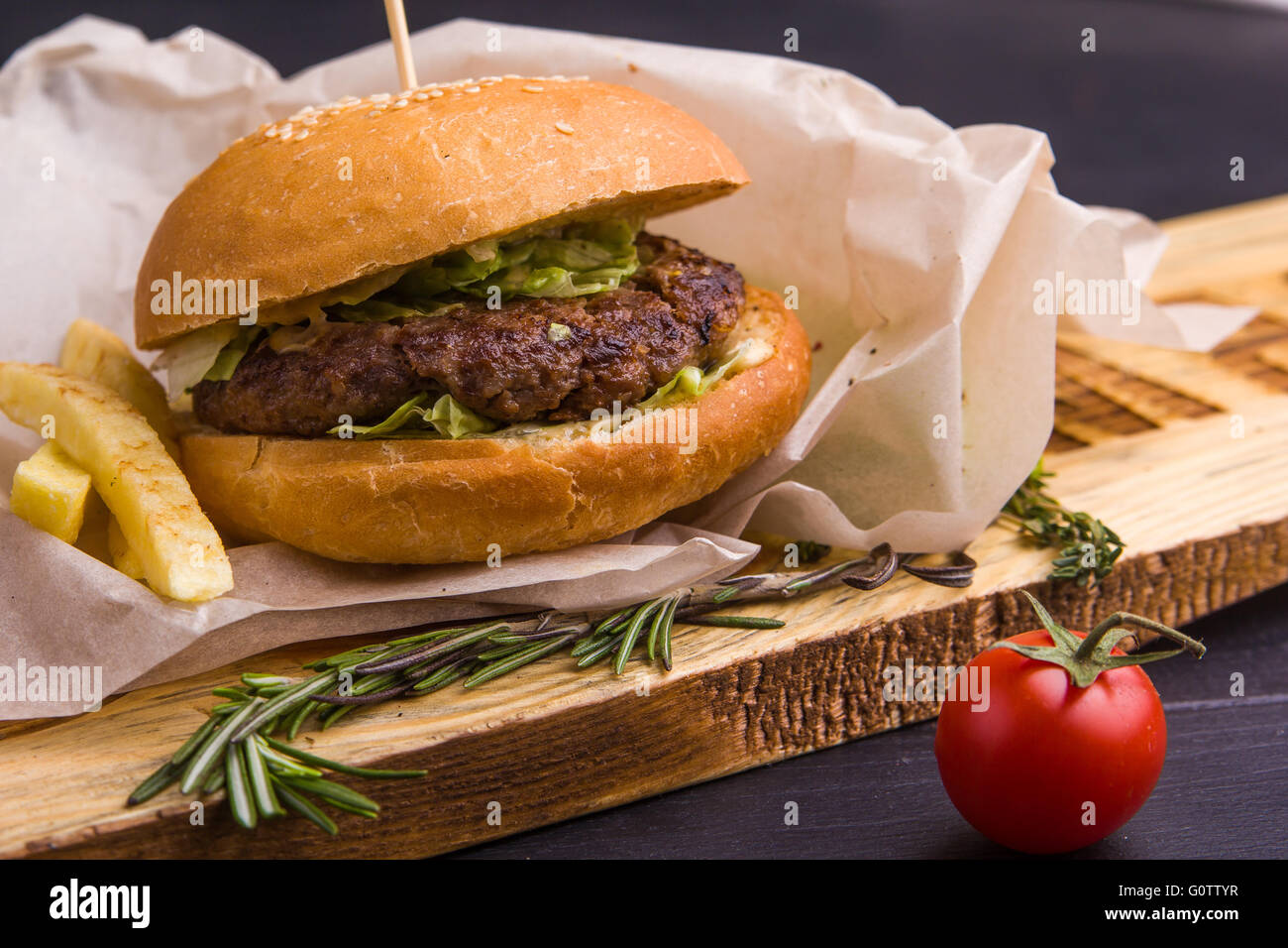 Concept : alimentation saine. Maison Gourmet Burger et garnir avec des ingrédients sur le fond sombre. Banque D'Images