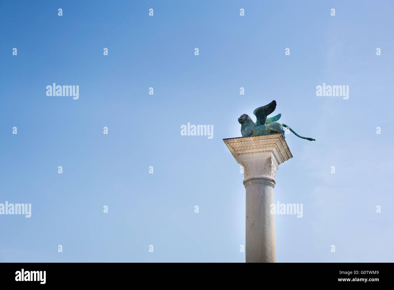 La statue de lion ailé sur une colonne, la copie de l'espace sur fond de ciel bleu Banque D'Images