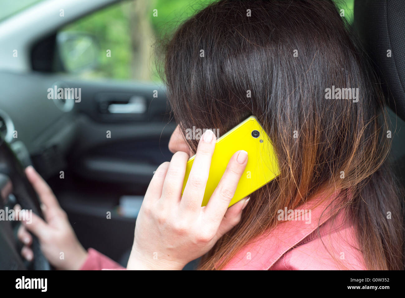 Image représentant une femme équitation dans une voiture et à parler au téléphone Banque D'Images