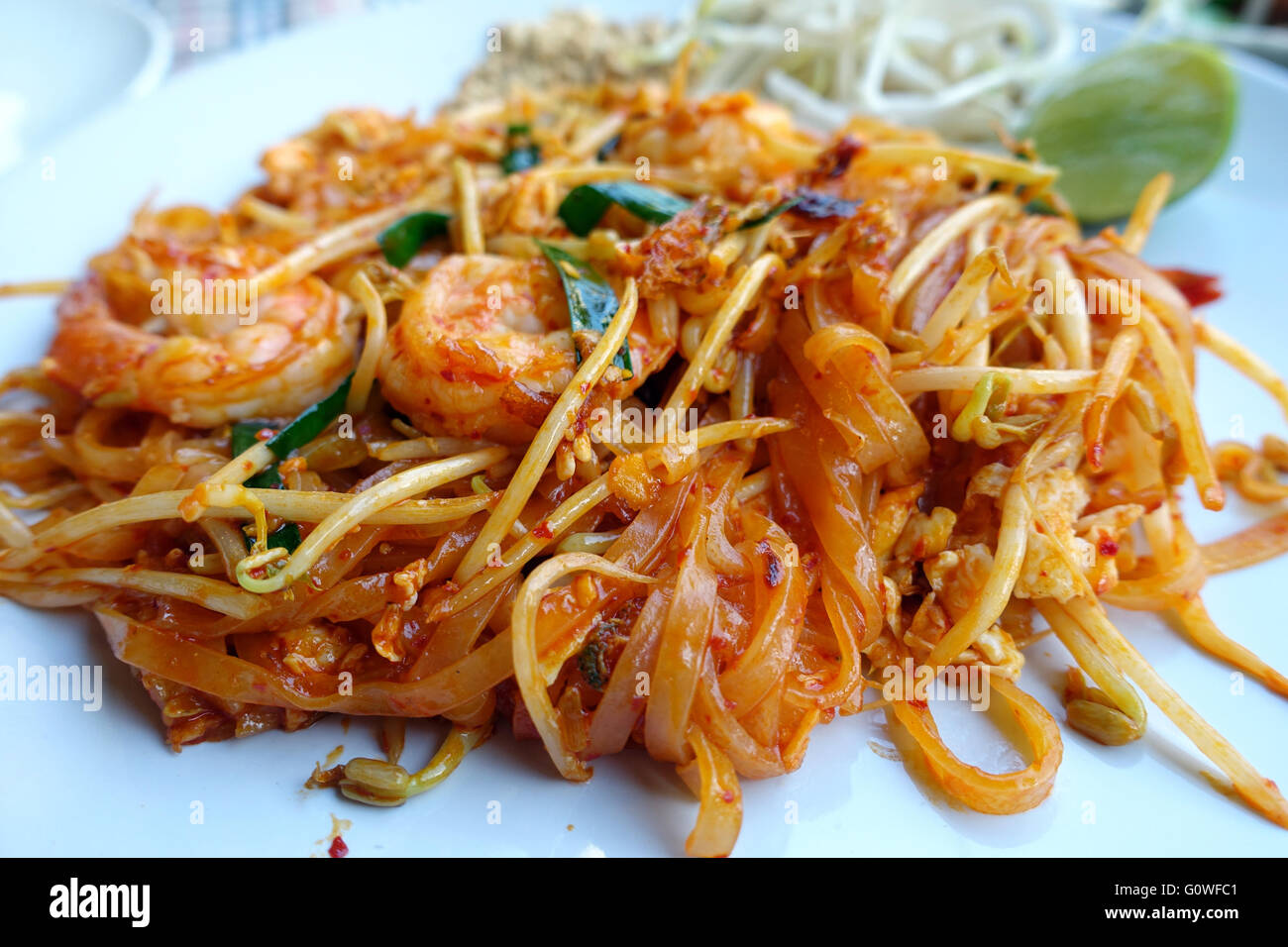 Une plaque de pad thaï est considéré sur une table dans un restaurant à Karon, Thaïlande 12 mars 2016. Phat Thai ou un Pad Thaï est un plat de nouilles traditionnelles de la cuisine thaïlandaise. Il se compose de nouilles de riz, les œufs battus, la sauce de poisson, la pâte de tamarin, l'ail haché, la poudre de chili, germes de haricots, les crevettes séchées, le tofu et la viande ou les fruits de mer en option. Il est garni avec les cacahuètes concassées et les feuilles de coriandre, citron vert, oignons de printemps. Photo : Alexandra Schuler/DPA - AUCUN SERVICE DE FIL- Banque D'Images