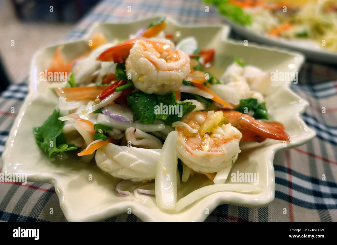 Une salade de fruits de mer faite de spicey de calmars et de crevettes (Yam Taleh)est vu sur une table dans un restaurant à Karon, Thaïlande 18 mars 2016. Photo : Alexandra Schuler/dpa Banque D'Images