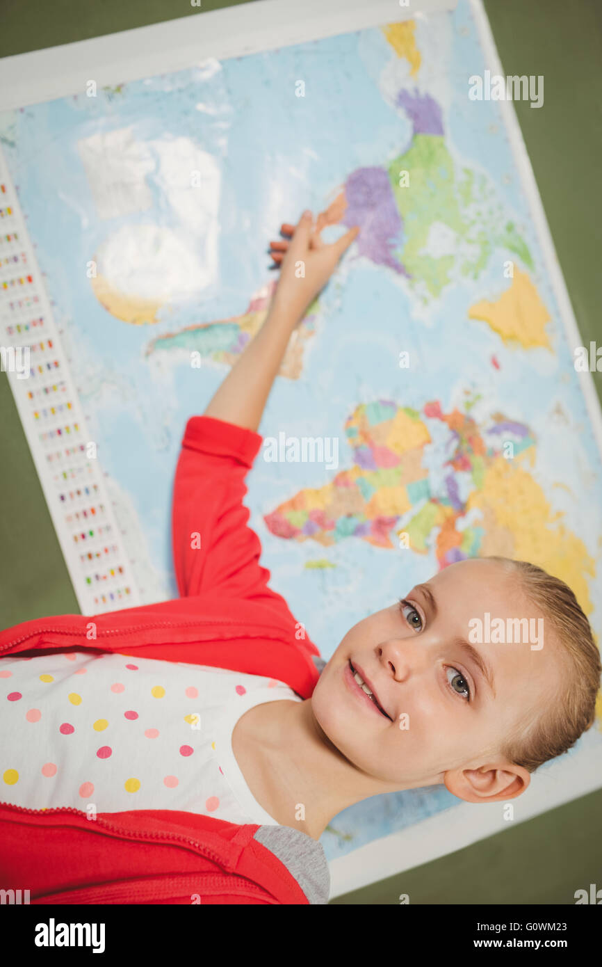 Girl pointing sur carte du monde Banque D'Images