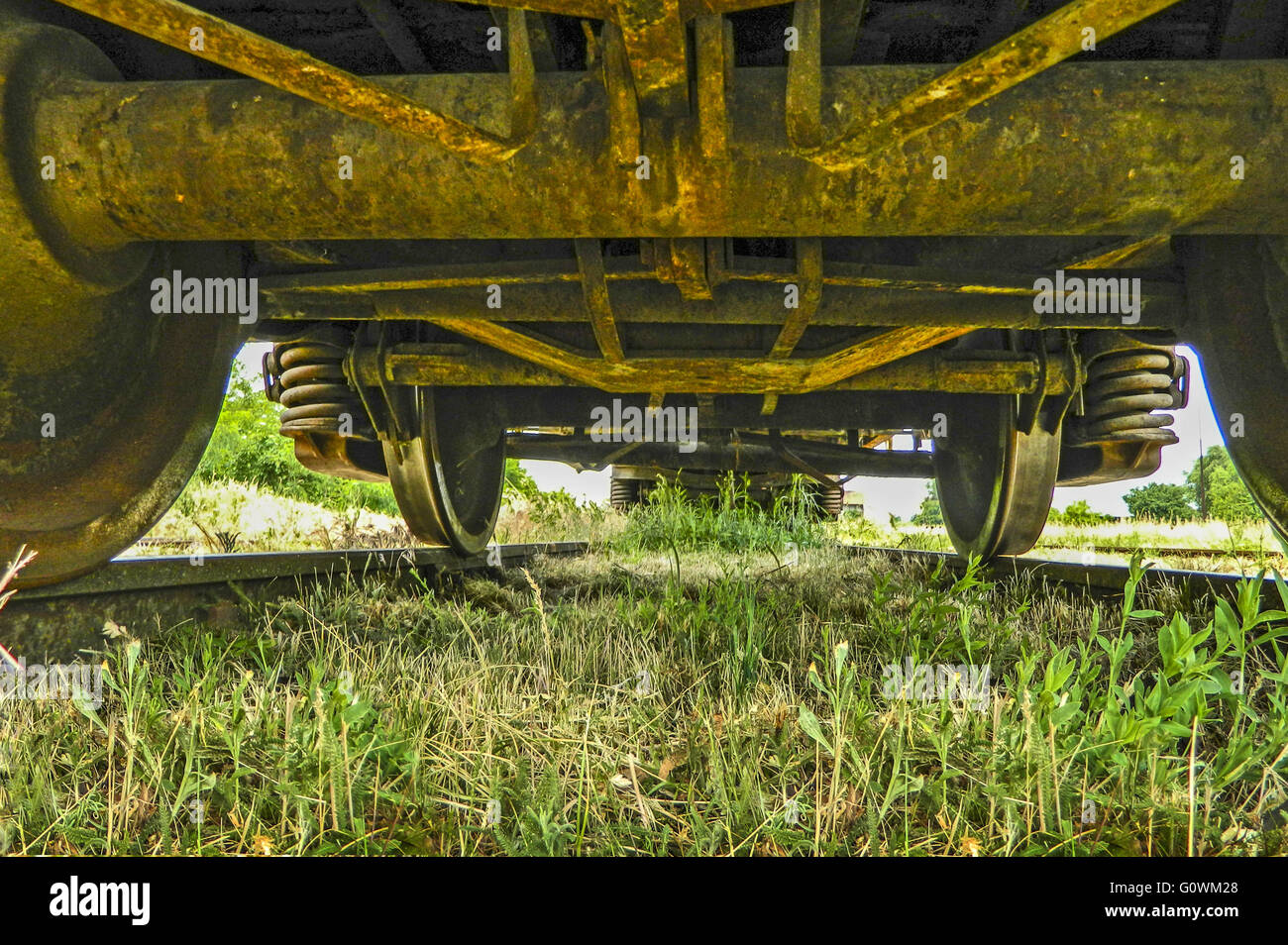 Vieux wagon debout sur la piste, qui est recouverte d'herbe. Banque D'Images