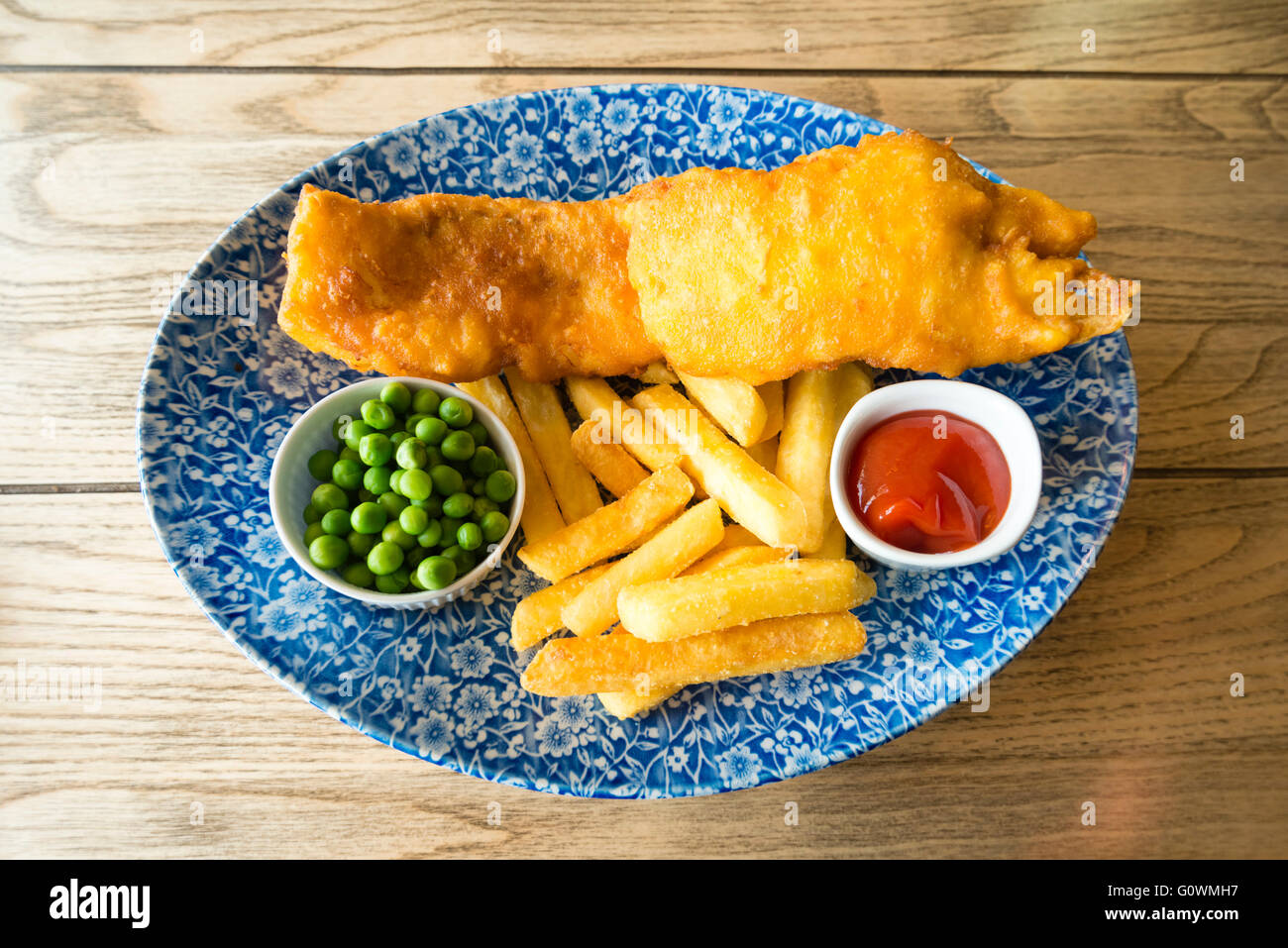 Fish & Chips avec les pois et le ketchup, repas dans un pub, au Royaume-Uni. Banque D'Images