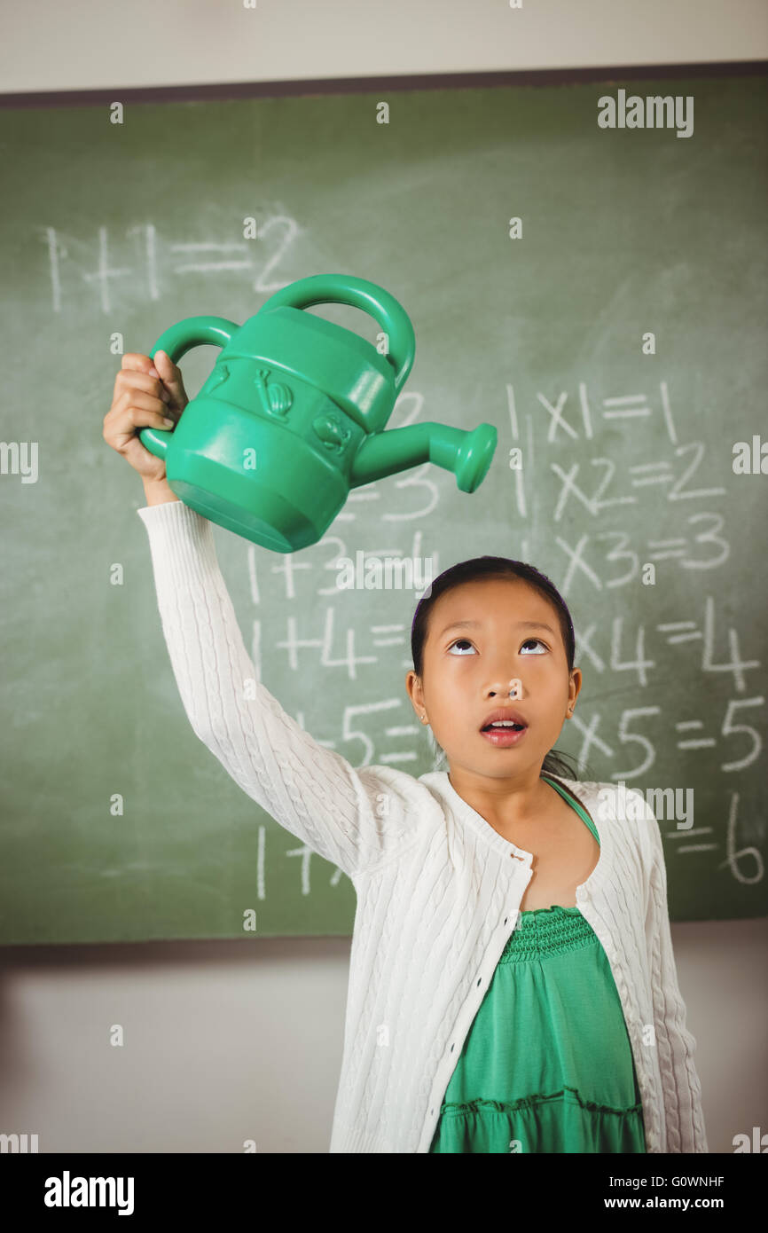 Lycéenne en utilisant un arrosoir Banque D'Images