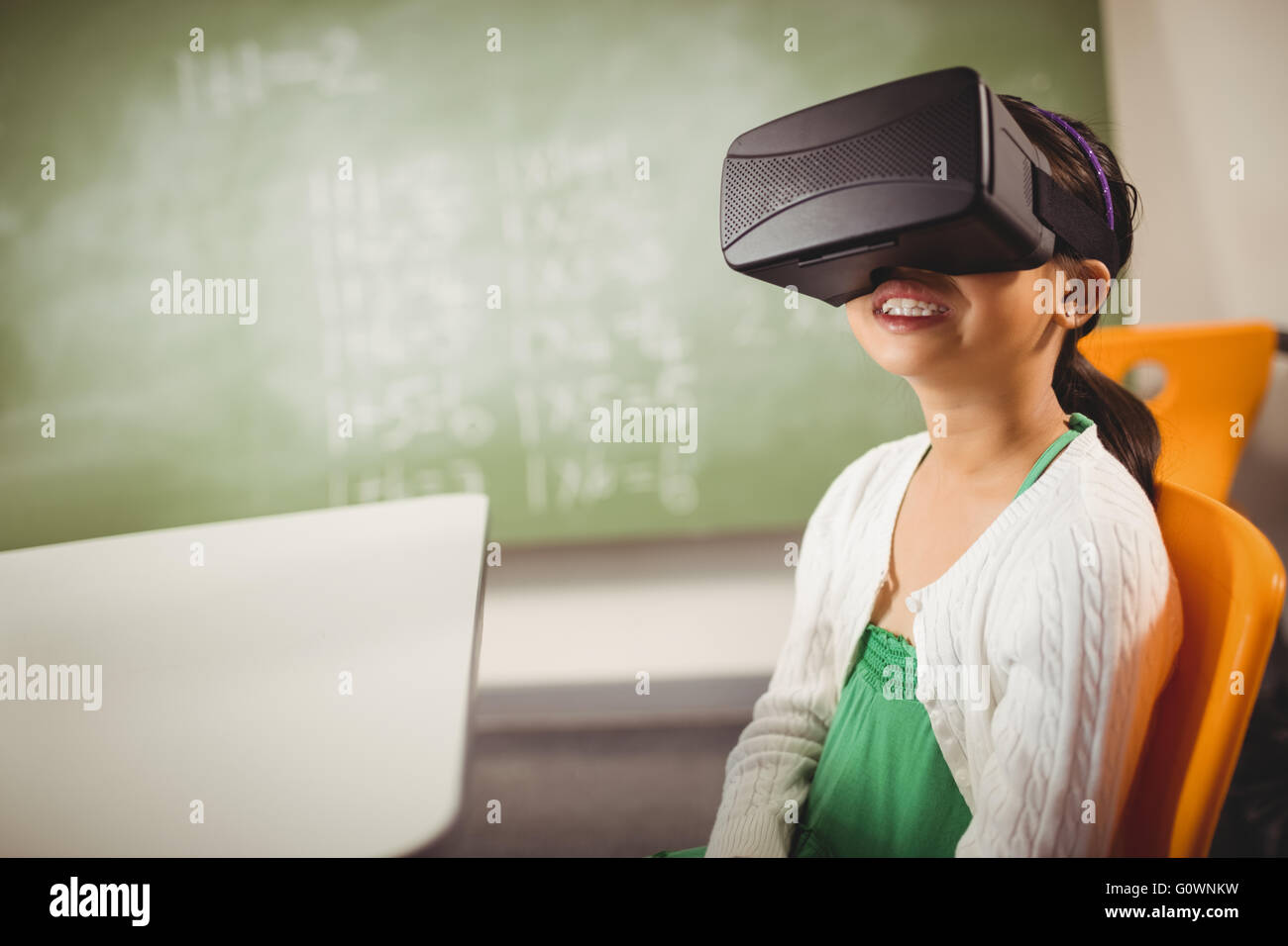 Jeune fille assise portant des lunettes de réalité virtuelle Banque D'Images