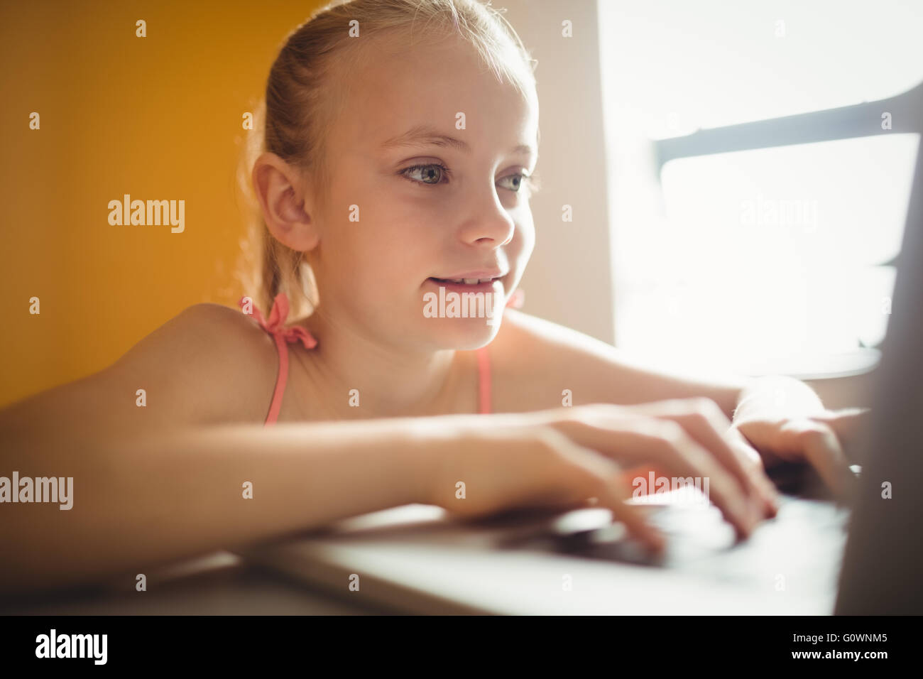 Assis à l'aide d'une fille à la maison de l'ordinateur Banque D'Images