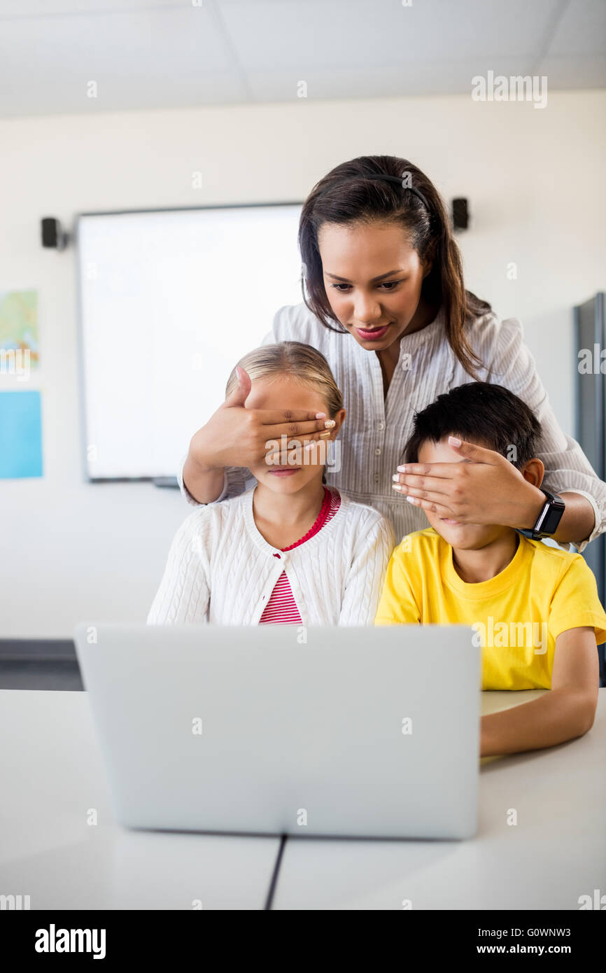 Les élèves enseignants couvrant les yeux devant l'ordinateur Banque D'Images