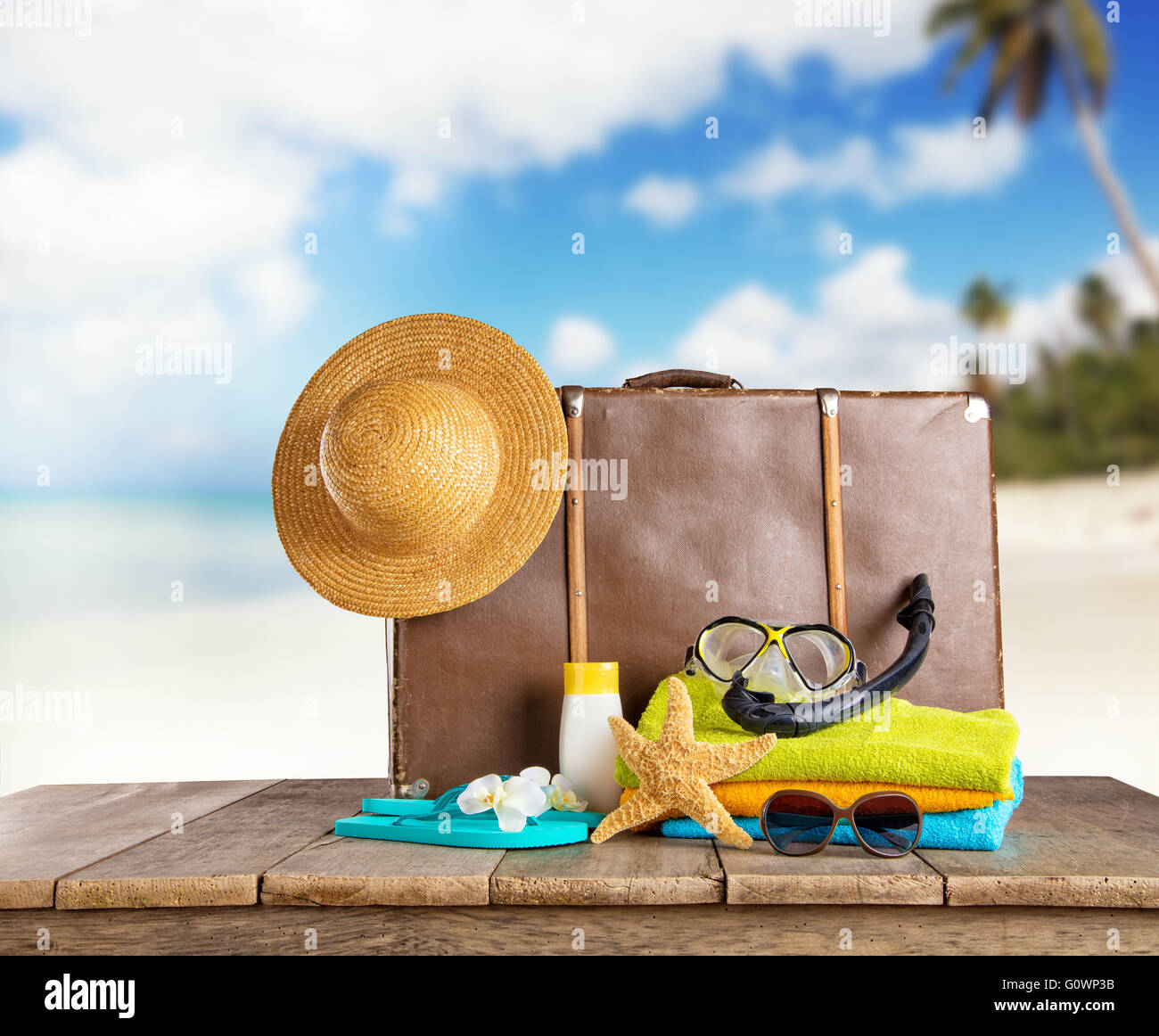 Valise et accessoires pour voyager placés sur des planches. Tropical Beach sur l'arrière-plan Banque D'Images